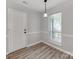 A bright dining area with wood floors features a window for natural light and a modern hanging lamp at 10736 Spruce Mountain Rd, Charlotte, NC 28214