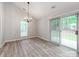 Dining area with modern chandelier, hardwood floors, and sliding door to the outdoor space at 10736 Spruce Mountain Rd, Charlotte, NC 28214