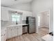 Well-lit kitchen with white cabinets, stainless steel appliances, and a window overlooking the yard at 10736 Spruce Mountain Rd, Charlotte, NC 28214