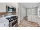 Modern kitchen with stainless steel appliances, white cabinets, and light countertops at 10736 Spruce Mountain Rd, Charlotte, NC 28214