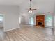 Spacious living room featuring vaulted ceilings, a brick fireplace, and wood-look flooring at 10736 Spruce Mountain Rd, Charlotte, NC 28214