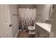 Bathroom features a curtained shower, toilet, and vanity with a gray cabinet at 109 Pepper Cir, Mooresville, NC 28117
