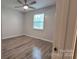 Bright bedroom with a window and hardwood floors, illuminated by a modern ceiling fan at 109 Pepper Cir, Mooresville, NC 28117