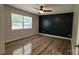 Bright bedroom featuring a modern accent wall, ceiling fan, and a large window for natural light at 109 Pepper Cir, Mooresville, NC 28117