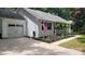 A well-maintained white home featuring a garage, American flag, and manicured garden at 109 Pepper Cir, Mooresville, NC 28117