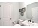 Clean half bathroom featuring a white vanity, decorative mirror, and neutral-colored walls at 114 Wingard Rd, Concord, NC 28025