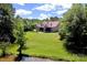 A beautiful two-story house features a well-manicured lawn and a tranquil pond, surrounded by lush trees at 114 Wingard Rd, Concord, NC 28025