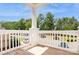 A condo balcony features white railings and wood flooring overlooking trees and parking at 11863 Ridgeway Park Dr, Charlotte, NC 28277