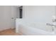 Bright bathroom featuring a white tiled bathtub and neutral tile flooring at 11863 Ridgeway Park Dr, Charlotte, NC 28277