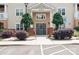 Apartment building entrance featuring a gray door, brick accents, and landscaped shrubs near parking at 11863 Ridgeway Park Dr, Charlotte, NC 28277