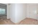 Neutral hallway featuring tile flooring, carpeted bedroom, and front door at 11863 Ridgeway Park Dr, Charlotte, NC 28277