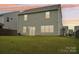 Home's back exterior with a well-kept lawn, sliding door, and neutral-toned siding at 120 Mooring Dr, Statesville, NC 28677