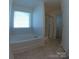 Bright bathroom featuring a soaking tub with tile surround and a glass-enclosed shower at 120 Mooring Dr, Statesville, NC 28677