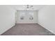 Sunny bedroom features neutral carpet, two windows, ceiling fan, and crisp white walls at 120 Mooring Dr, Statesville, NC 28677