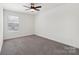 Bedroom with neutral carpet, large window, and ceiling fan for optimal comfort at 120 Mooring Dr, Statesville, NC 28677