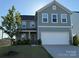 Charming two-story home featuring a two-car garage and a well-manicured front lawn on a sunny day at 120 Mooring Dr, Statesville, NC 28677
