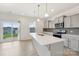 Kitchen with quartz island, gray cabinets, stainless appliances, and access to patio at 120 Mooring Dr, Statesville, NC 28677