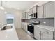 Gray kitchen cabinets, stainless steel appliances, and light countertops with a gray backsplash at 120 Mooring Dr, Statesville, NC 28677