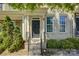 Charming brick townhouse featuring landscaped front yard, trimmed bushes, and a black front door at 1225 Assembly St, Belmont, NC 28012