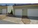 Attached one-car garage with white door and driveway in front of this charming light green townhome at 1225 Assembly St, Belmont, NC 28012