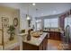 Well-lit kitchen with a granite countertop island, stainless steel appliances, and wood cabinets at 1225 Assembly St, Belmont, NC 28012
