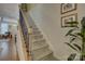 Carpeted stairs with stained wood railing and decorative iron spindles lead to the upper level at 1225 Assembly St, Belmont, NC 28012