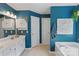 Stylish bathroom with bright blue walls, soaking tub, and ample counter space at 1310 Bellhook Nw Pl, Concord, NC 28027