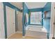 Bright blue bathroom featuring a soaking tub and a separate glass door shower at 1310 Bellhook Nw Pl, Concord, NC 28027