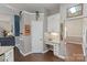 Well-appointed kitchen with white cabinetry, granite countertops, and adjacent living area access at 1310 Bellhook Nw Pl, Concord, NC 28027
