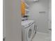 Bright laundry room featuring a modern washer and dryer, cabinets, and shelves at 1310 Bellhook Nw Pl, Concord, NC 28027