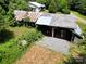 Aerial view of weathered barns nestled amongst verdant trees and vegetation on a large lot at 140 Dalu Ln, Harmony, NC 28634