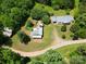 Aerial view of property with two buildings, driveway, grassy areas, and surrounding trees at 140 Dalu Ln, Harmony, NC 28634