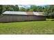 This gray barn has a metal roof, multiple doors, and windows on a property with a grassy yard at 140 Dalu Ln, Harmony, NC 28634