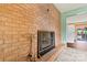 Close up of a brick fireplace with a screen and tools with an entry way into another room at 141 Porter Rd, Statesville, NC 28625