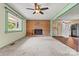 Open living room with brick fireplace, large window, ceiling fan, and entry to the kitchen at 141 Porter Rd, Statesville, NC 28625