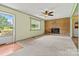Bright living room boasting a brick fireplace, window, ceiling fan and entry to a side door at 141 Porter Rd, Statesville, NC 28625