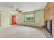 Bright living room featuring a brick fireplace, window, ceiling fan and a front door with storm door at 141 Porter Rd, Statesville, NC 28625