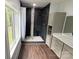 Modern bathroom features a luxurious walk-in shower with black tile and a pebble floor at 1543 Withers Dr, Denver, NC 28037