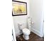 Clean bathroom with toilet, dark wood floors, and decorative miniature cabinet at 1543 Withers Dr, Denver, NC 28037