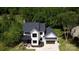 Charming two-story home with black roof, white siding, and two-car garage, set amongst lush greenery at 1543 Withers Dr, Denver, NC 28037