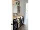 Well-organized laundry room featuring sleek, modern black washer and dryer beneath stylish gray cabinets at 1543 Withers Dr, Denver, NC 28037