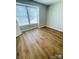 Well-lit bedroom with light neutral paint, hardwood floors and large window providing natural light at 1624 Arlyn Cir # G, Charlotte, NC 28213