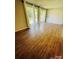 Spacious living room featuring hardwood floors, neutral paint, and sliding glass doors to a private balcony at 1624 Arlyn Cir # G, Charlotte, NC 28213