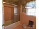 Bathroom featuring pink tile, a classic shower-tub combination, and a traditional window at 170 Heritage Ln, Salisbury, NC 28147