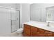 Bathroom with a glass door shower, vanity with wood cabinets, and a large mirror at 17119 Doe Valley Ct, Cornelius, NC 28031