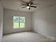 Bedroom featuring a ceiling fan and large window offering views of the outdoors at 17119 Doe Valley Ct, Cornelius, NC 28031
