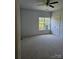 A bright and airy bedroom with a large window, plush carpet, a ceiling fan and a double door closet at 17119 Doe Valley Ct, Cornelius, NC 28031