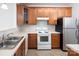 Bright kitchen with wood cabinets, white countertops, stainless steel appliances, and a neutral tiled floor at 17119 Doe Valley Ct, Cornelius, NC 28031