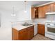 Bright kitchen showcasing wood cabinets, essential appliances, and stylish lighting at 17119 Doe Valley Ct, Cornelius, NC 28031