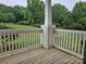 Exterior view from a wood patio, looking out to green lawn and foliage and white fence at 17119 Doe Valley Ct, Cornelius, NC 28031